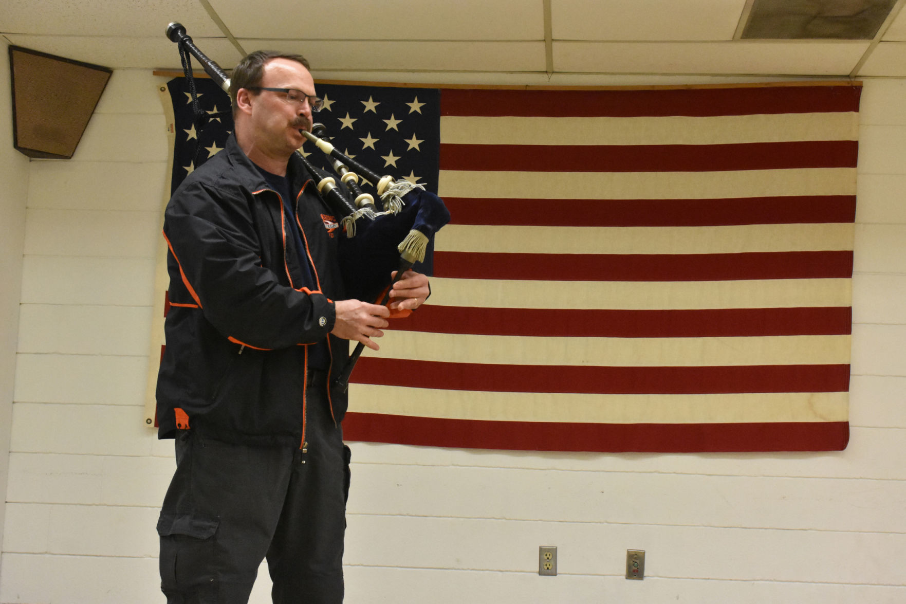 Rich Hoege plays bagpipes at graduation